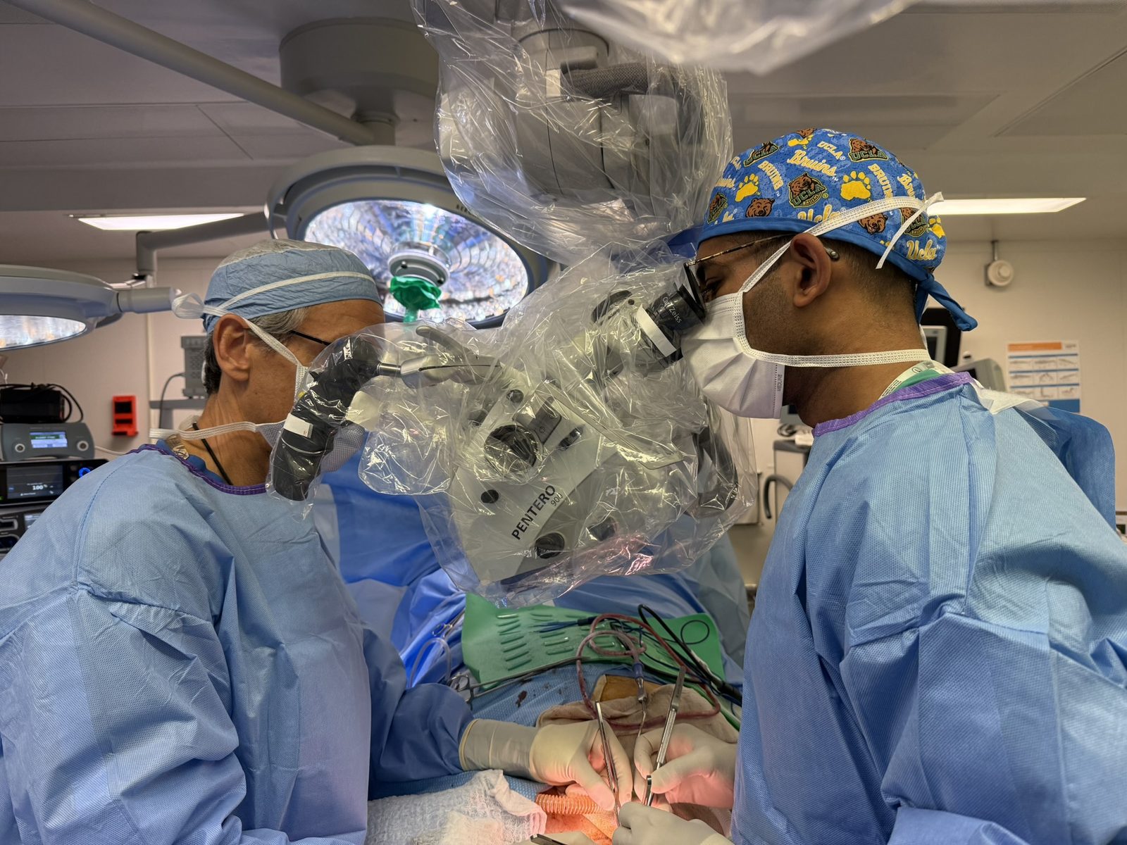 Dr. Gidumal operating with a surgical microscope at UCLA
